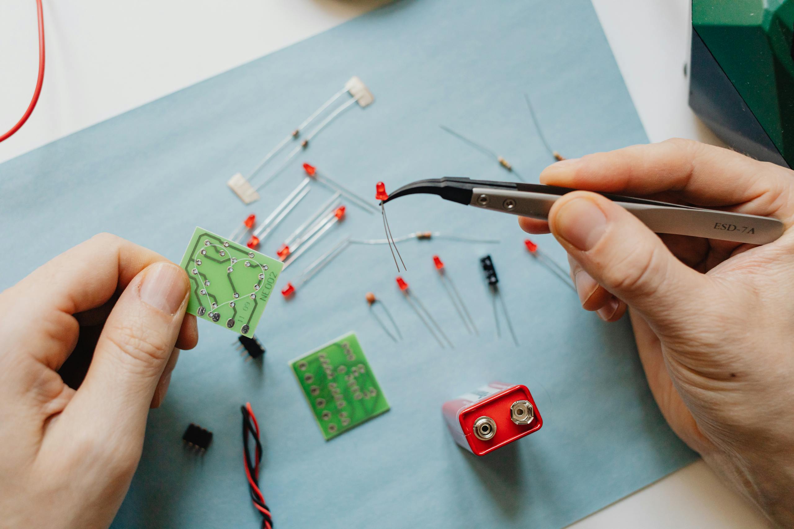 A close-up view of electronic repair with tools and circuit board components.